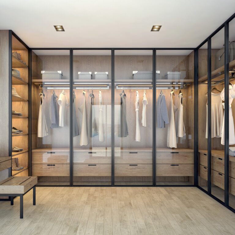 Modern Walk-In Closet With Glass Doors, Built-In Wooden Shelves, Integrated Lighting, And Walk-In Closet Organizers.