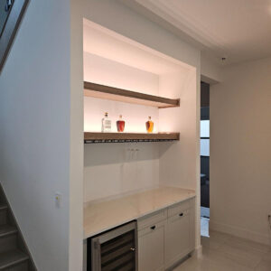 Tiny pantry and home bar with open shelving, under-counter storage, and integrated wine fridge.