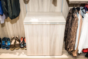 Custom reach in closet with built in shoe storage and cabinet
