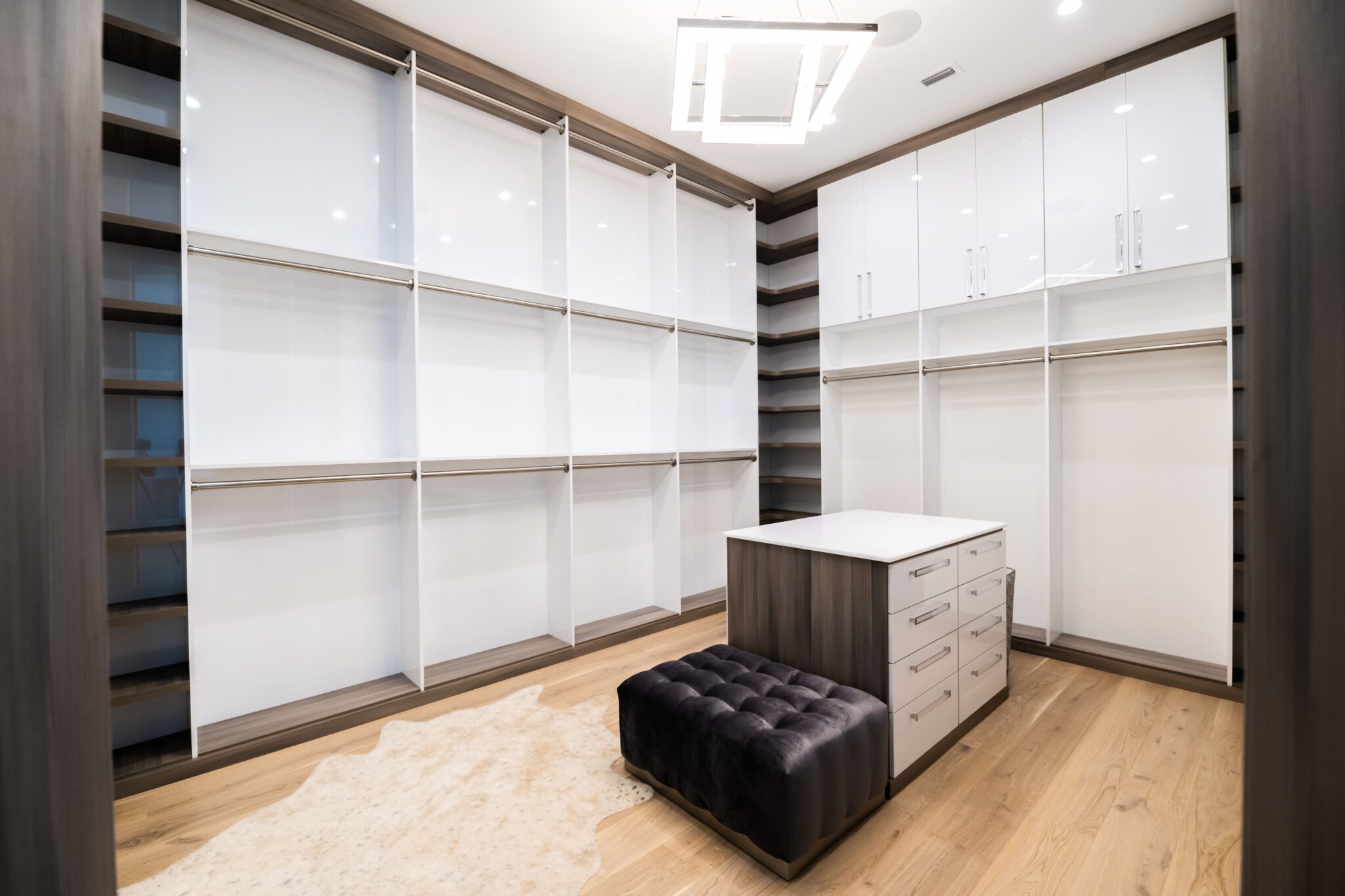 Modern walk in closet in medium dark wood and white pearl finish