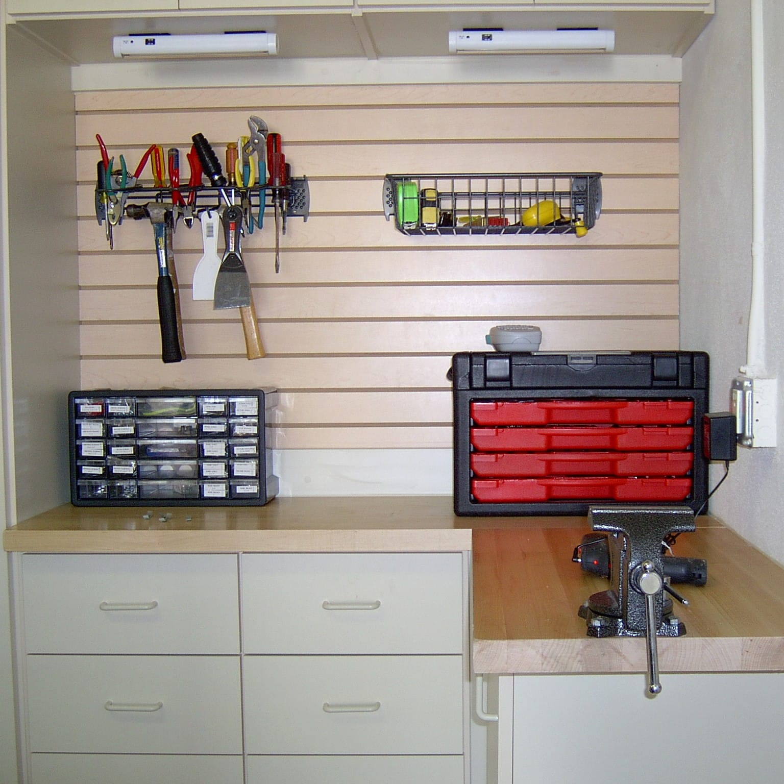 Custom garage workbench with tool storage, slatwall, and drawer cabinets.