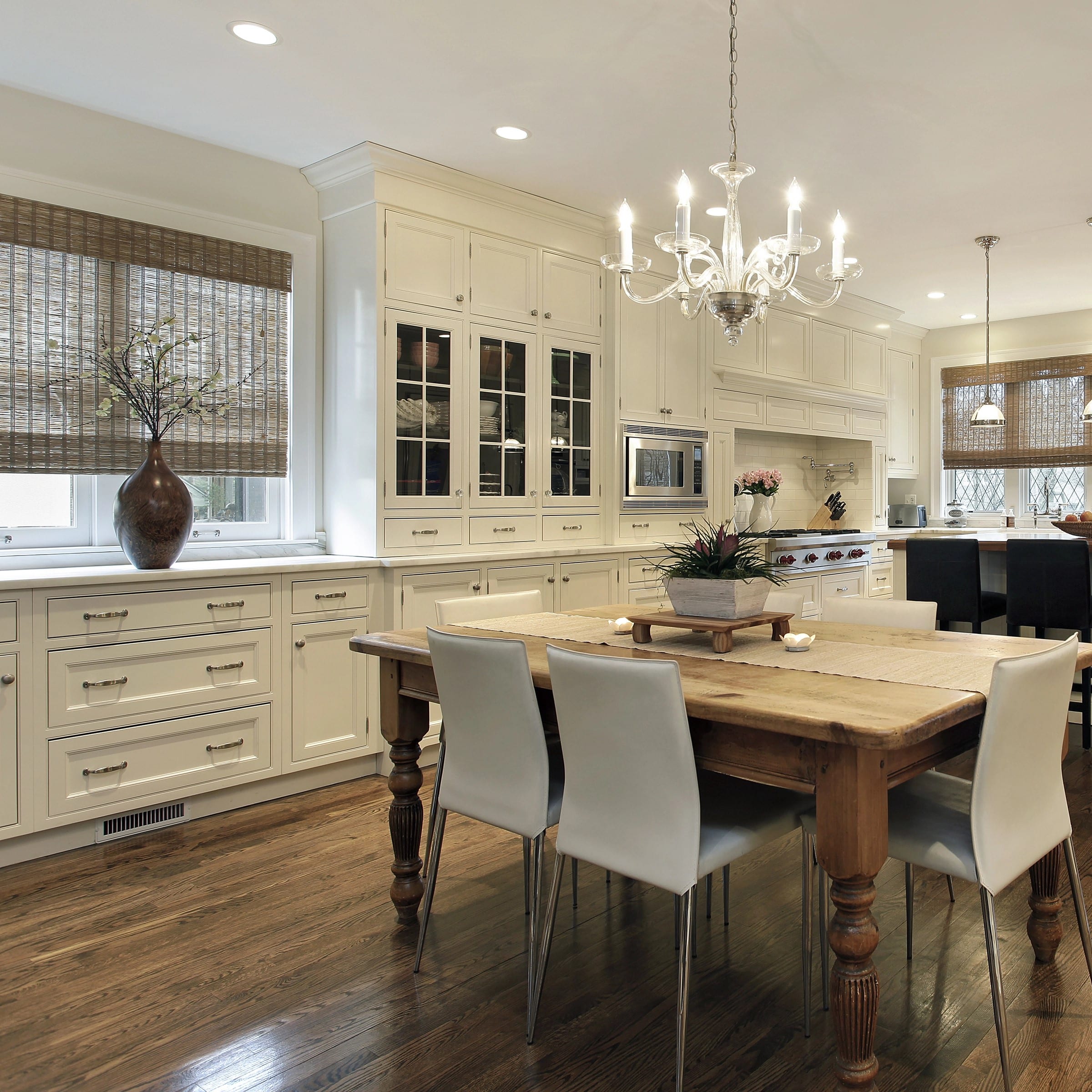 Elegant kitchen with custom white pantry cabinets and rustic dining table