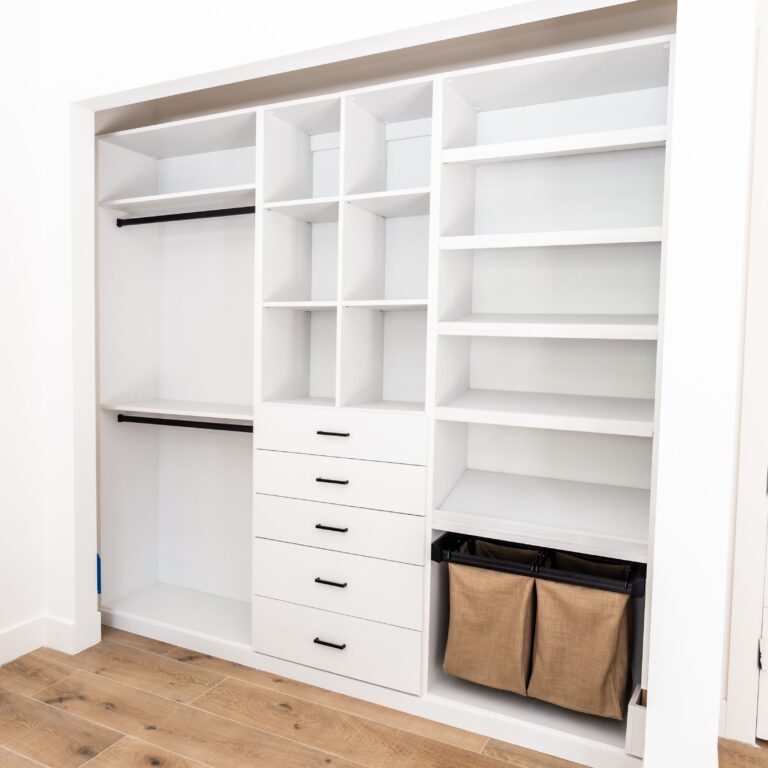 Reach-In Closet With Custom Shelving, Drawers, And Hanging Spaces For Optimal Storage And Organization.