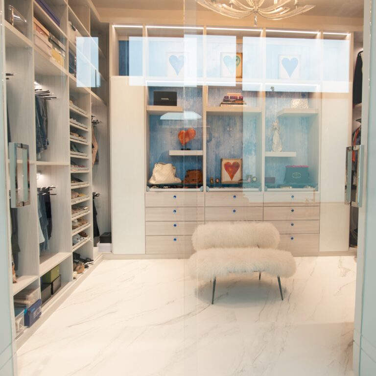 Modern Walk-In Closet With Integrated Shoe Storage, Slanted Racks, Glass Doors, Custom Drawers, And Plush Seating.