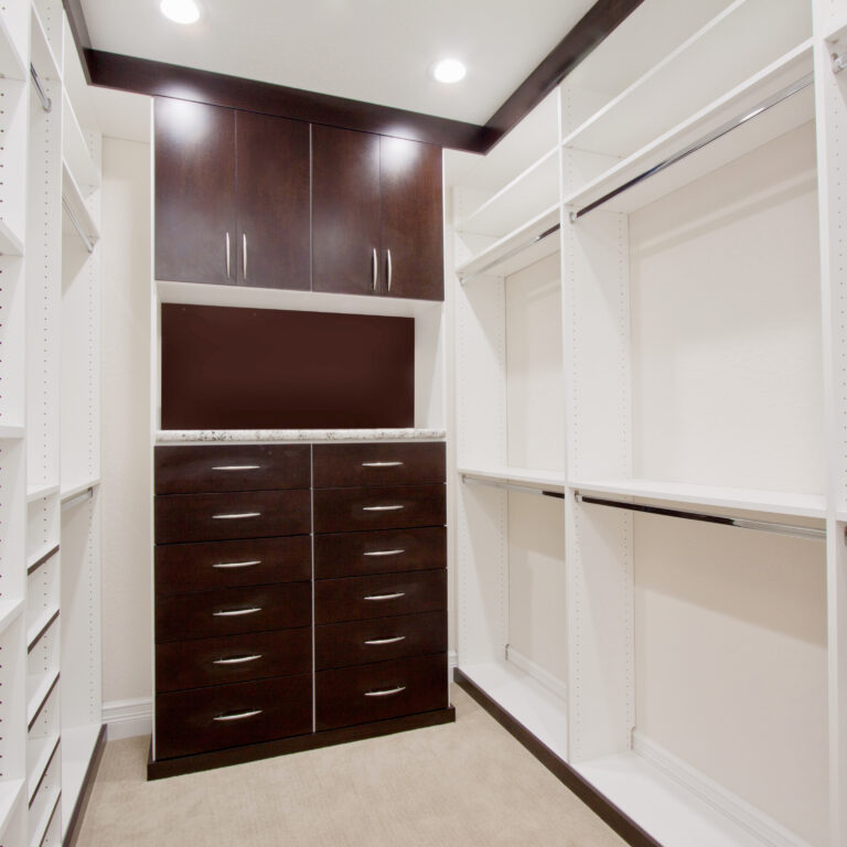 Small Walk-In Closet With Custom Dark Wood Cabinets, White Shelving, Dual-Level Hanging Rods, And Efficient Lighting.