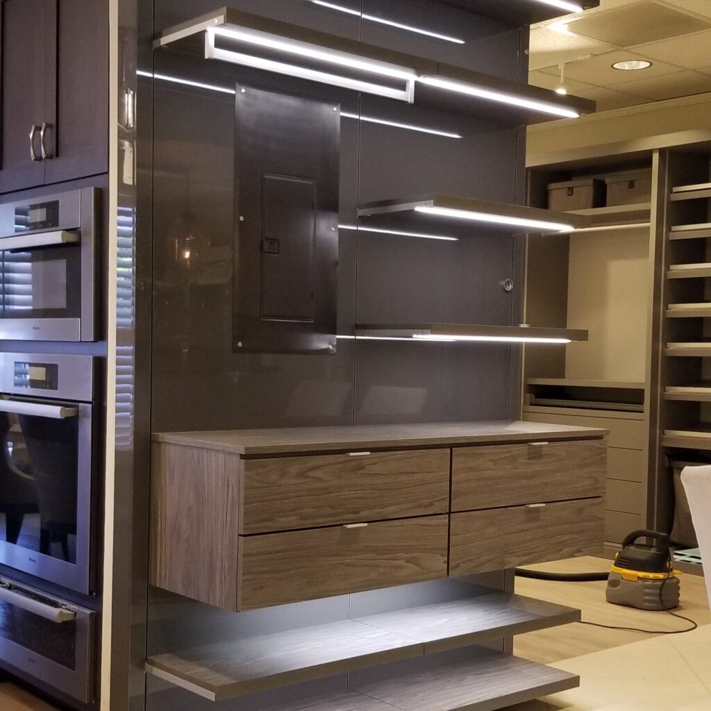 Premium illuminated shelving and wood drawer system at the JL Closets Boca Raton showroom, showcasing custom closet systems Boca Raton with built-in closet lighting and modern finishes. Ideal for boca raton custom closets and closet accessories Boca Raton.